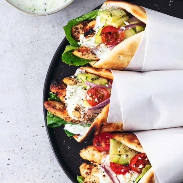 Three Juicy Gyros chicken wraps with lettuce, tomatoes, cucumbers, onions, and tzatziki sauce.